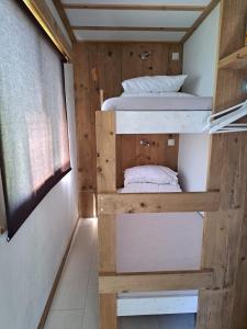 a bedroom with two bunk beds in a tiny house at Zeeuwse Landhoeve Chalet in Brouwershaven