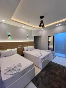een slaapkamer met twee bedden en een groot raam bij Triple garden view hotel in Caïro