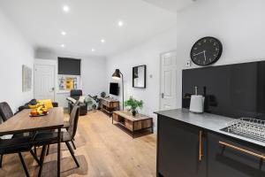 cocina y sala de estar con reloj en la pared en Central Brighton 2 Bed Flat, en Brighton & Hove 7 fotos más
