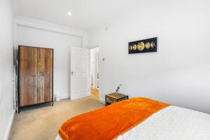 Un dormitorio con una cama con una manta naranja. en Central Brighton 2 Bed Flat, en Brighton & Hove