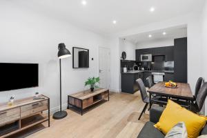 Una sala de estar con mesa de comedor y una cocina. en Central Brighton 2 Bed Flat, en Brighton & Hove