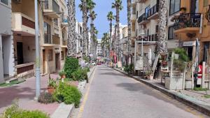 an empty street in a city with palm trees at 139 Taormina Apartment in St Paul's Bay