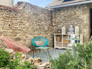 a patio with two chairs and a stone wall at Appart 2 Chambres, Centre Ville, Parking privé clos, Local vélo in Mayenne +27 photos