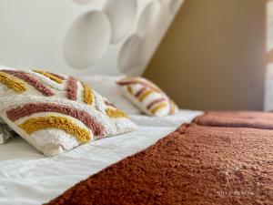 a bed with two pillows on top of it at Appartement Villa Medena - Classé 3 étoiles in Mayenne +12 photos