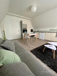a living room with a couch and a table at Appart 2 Chambres, Centre Ville, Parking privé clos, Local vélo in Mayenne