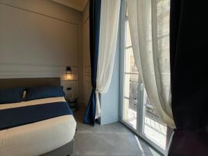 a bedroom with a bed and a large window at Philosofia in Naples