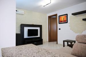 a living room with a television and a couch at Bassa Marea in Chioggia