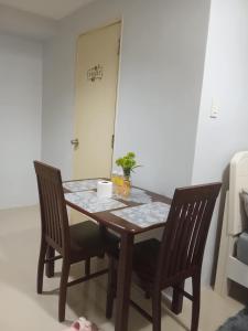 a dining room table with two chairs and a table at Sea Residences david in Manila