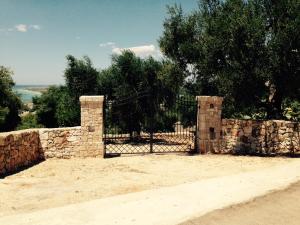 valla de piedra con puerta y pared de piedra en Case Vacanza Le Arcate, en Morciano di Leuca