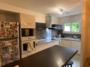 a kitchen with a table and a refrigerator at Family home in Mérignac