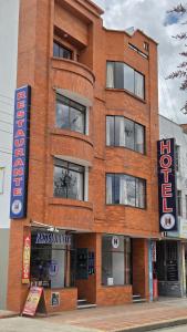 a brick building with a sign in front of it at Hotel Imperial in Chiquinquirá