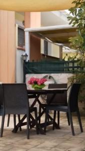 stół i krzesła z kwiatami na patio w obiekcie CASAVACANZA - Marina w mieście San Salvo