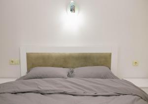 una camera bianca con un grande letto con testiera di Lumari Apartment a Kakhaberi