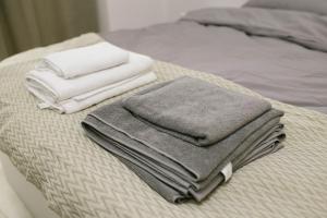 una pila di asciugamani appoggiata sopra un letto di Lumari Apartment a Kakhaberi