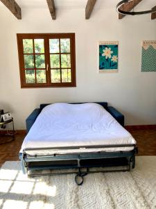 a bed sitting in a room with a window at Villa de bord de plage in Pinarellu