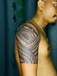 a man with a traditional tattoo on his arm at Dream Tattoos in Weligama
