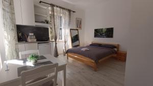 a bedroom with a bed and a table in a room at San Eleuterio Guesthouse in Poreč