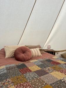 a bed with a quilt and pillows on it at Glamping Josephine in Geel +8 photos