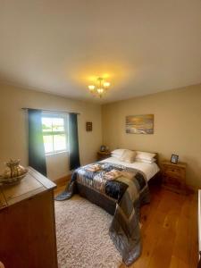 a bedroom with a large bed and a window at Carraig Ban Cottage Dungloe in Ardeevin