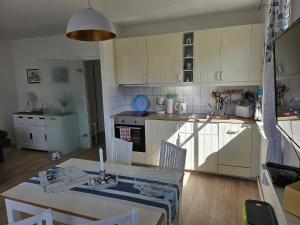 a kitchen with a table and a sink and a table and chairs at Strandnahe FeWo Sonneneck auf Poel mit Garten & Stellplatz in Insel Poel