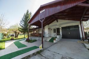 a house with a porch with green grass at Villa Bravo Breaza in Breaza