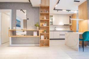 a kitchen with white cabinets and a blue chair at Studio President 80 in Craiova