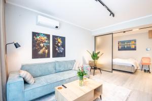 a living room with a blue couch and a table at Studio President 80 in Craiova