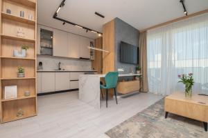 an open kitchen with a table and a green chair at Studio President 80 in Craiova