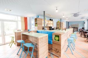 a kitchen with blue chairs and a counter at HI Youth Hostel Lindau in Lindau