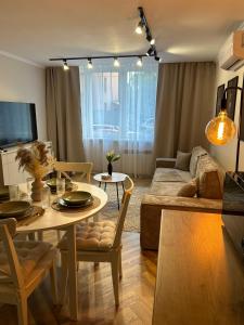 una sala de estar con una mesa y un sofá en Apartament Kosynierów, en Przemyśl