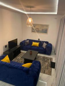 a living room with a blue couch and a table at Peanut Cottage Bulawayo in Bulawayo