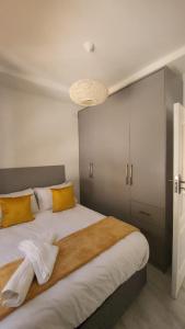 a bedroom with a large bed with yellow pillows at Peanut Cottage Bulawayo in Bulawayo