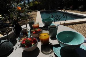 una mesa con tazones de fruta y bebidas. en Le Jardin de Mazan, en Mazan