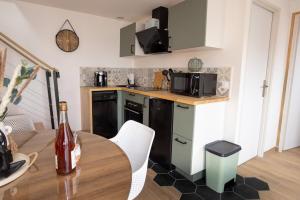 a kitchen with a table and a kitchen with black appliances at L'avocette Gîtes de la réserve in Grand-Laviers