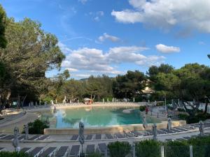 a large swimming pool in a park with trees at Appartement Village P&V domaine du golf Pont Royal Provence avec PARC AQUATIQUE in Mallemort +14 photos