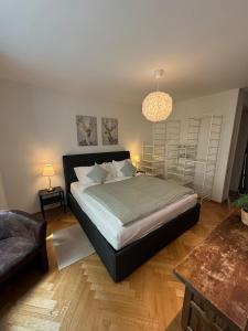 a bedroom with a large bed and a chandelier at Zürich Central Station Apartment, 2 bedroom & Sofabed in Zürich