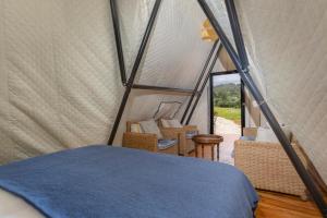 a bedroom in a tent with a bed and chairs at Aljezur Luxury Bedouin Tent in São Luis +16 photos