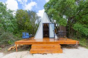 a tent with a table and chairs on a wooden deck at Aljezur Luxury Bedouin Tent in São Luis