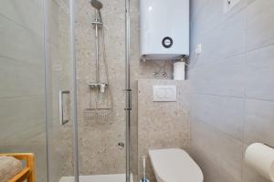 ein Badezimmer mit Dusche, Toilette und Waschbecken in der Unterkunft Cozy Holiday Home Punta Kriza in Punta Križa