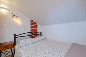 ein Schlafzimmer mit einem Bett und einer Ziegelwand in der Unterkunft Cozy Holiday Home Punta Kriza in Punta Križa