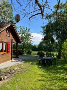 a picnic table in the grass next to a cabin at Le Chamois in Le Tartre
