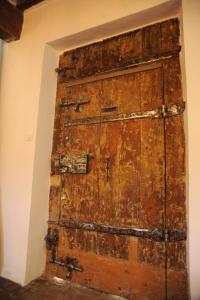 una antigua puerta de madera en la esquina de una habitación en Le Jardin de Mazan, en Mazan