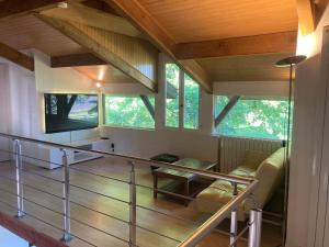 a room with a staircase with a couch and a tv at Gavial - Grande maison avec piscine in Léon