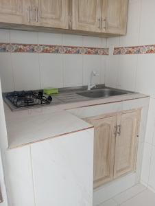a white kitchen with a sink and a stove at CABAÑAS CALIPSO, 2 piso in Coveñas +10 photos