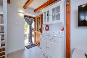 eine Küche mit einem weißen Schrank und einer Treppe in der Unterkunft Cozy Holiday Home Punta Kriza in Punta Križa