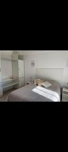 Un dormitorio con una cama grande con sábanas blancas. en Centro, en Paraná