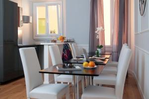 a dining room table with white chairs and a laptop on it at St. Peter Vatican Rooms in Rome