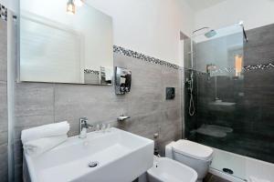 a white bathroom with a sink and a toilet at St. Peter Vatican Rooms in Rome +29 photos