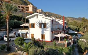 a white house with a palm tree and a building at Villa Vittoria in Cefalù