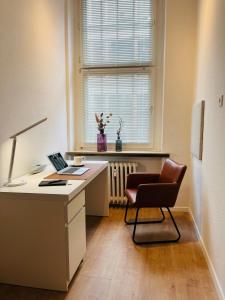 an office with a desk with a laptop and a chair at Modernes City-Apartment mit Highspeed-WLAN & Top-Lage - Easy Stay Wuppertal in Wuppertal